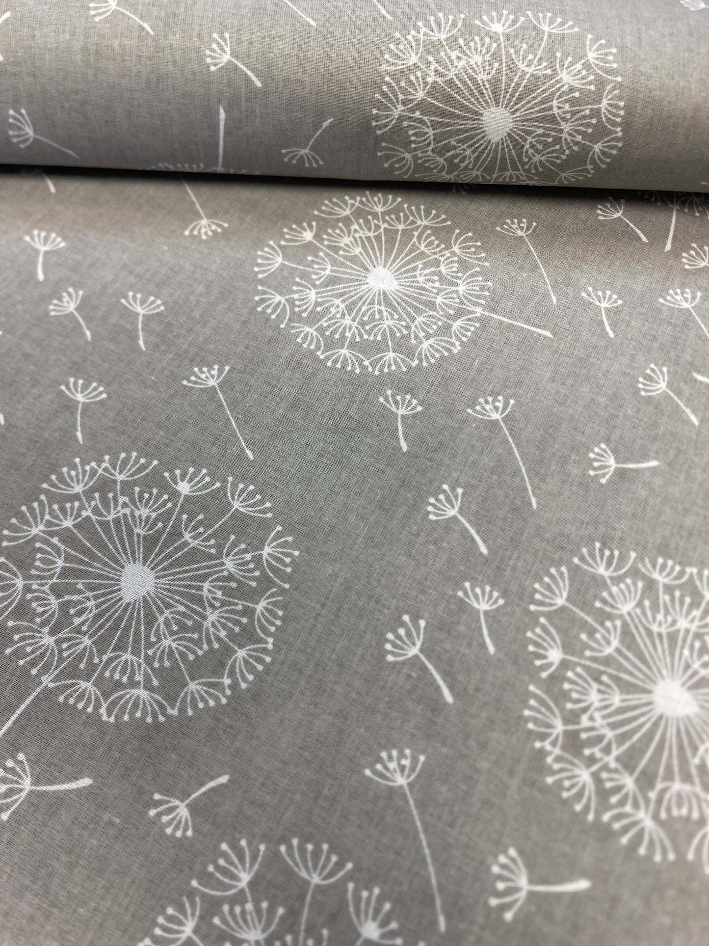 100% Kokvilnas audums - pieneņpūkas uz pelēka fona 125 g/m²