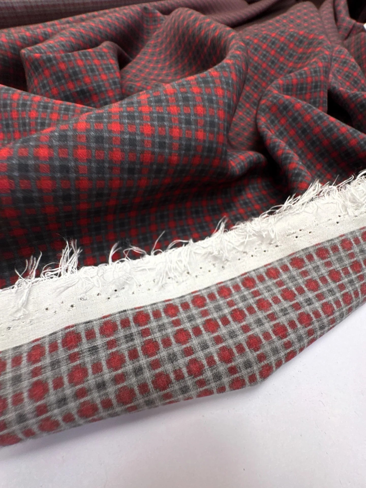 Image d’un tissu italien 100 % viscose à motif rouge et gris – disponible en ligne chez Šarlotes audumi