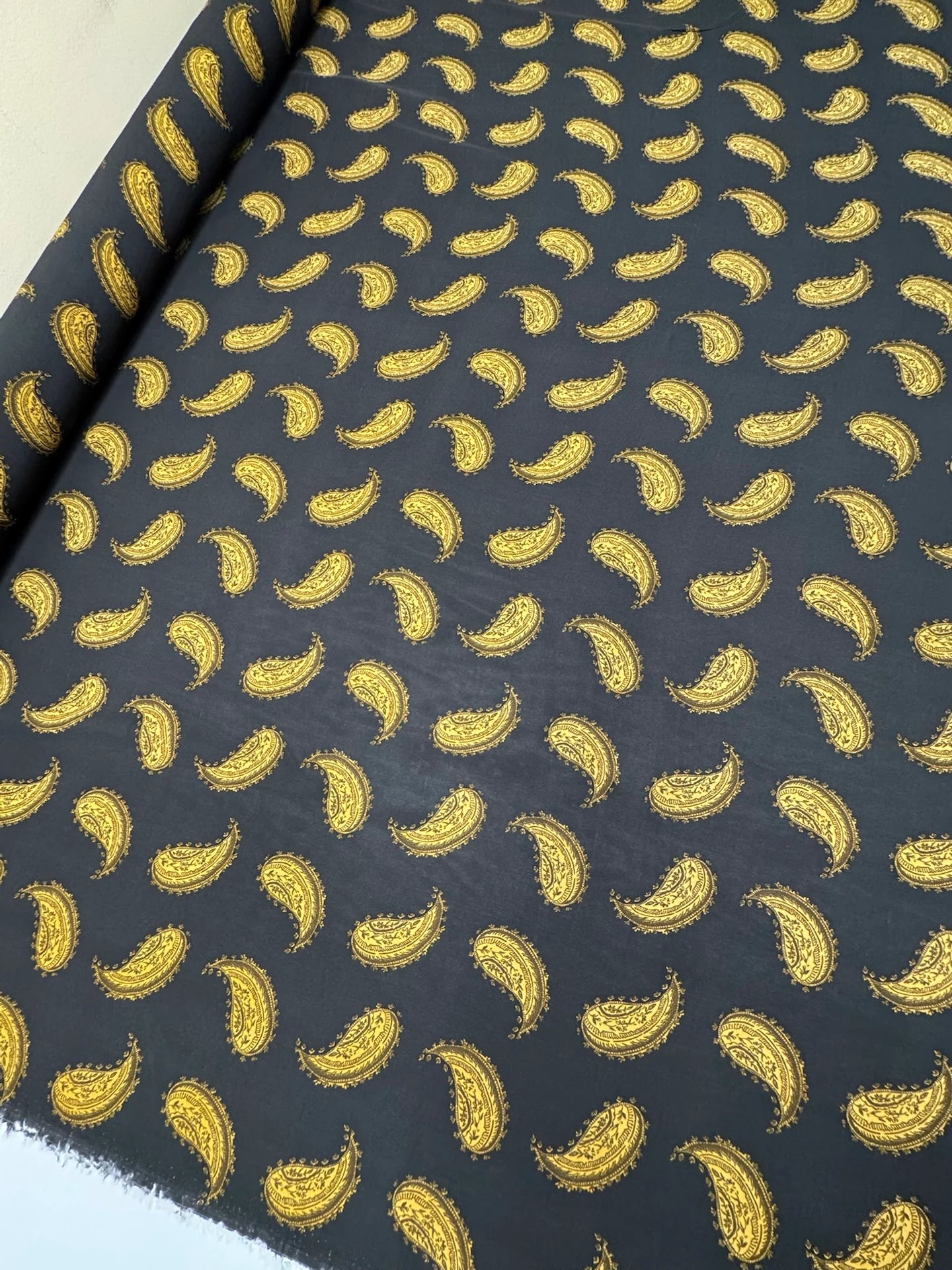 Bild mit italienischem Chiffonstoff aus 100% Viskose mit goldenem Paisley-Muster auf schwarzem Hintergrund – online erhältlich bei Šarlotes audumi