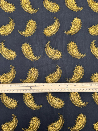 Bild eines italienischen 100 % Viskose-Chiffonstoffs mit goldenem Paisley-Muster auf schwarzem Hintergrund – online erhältlich bei Šarlotes audumi