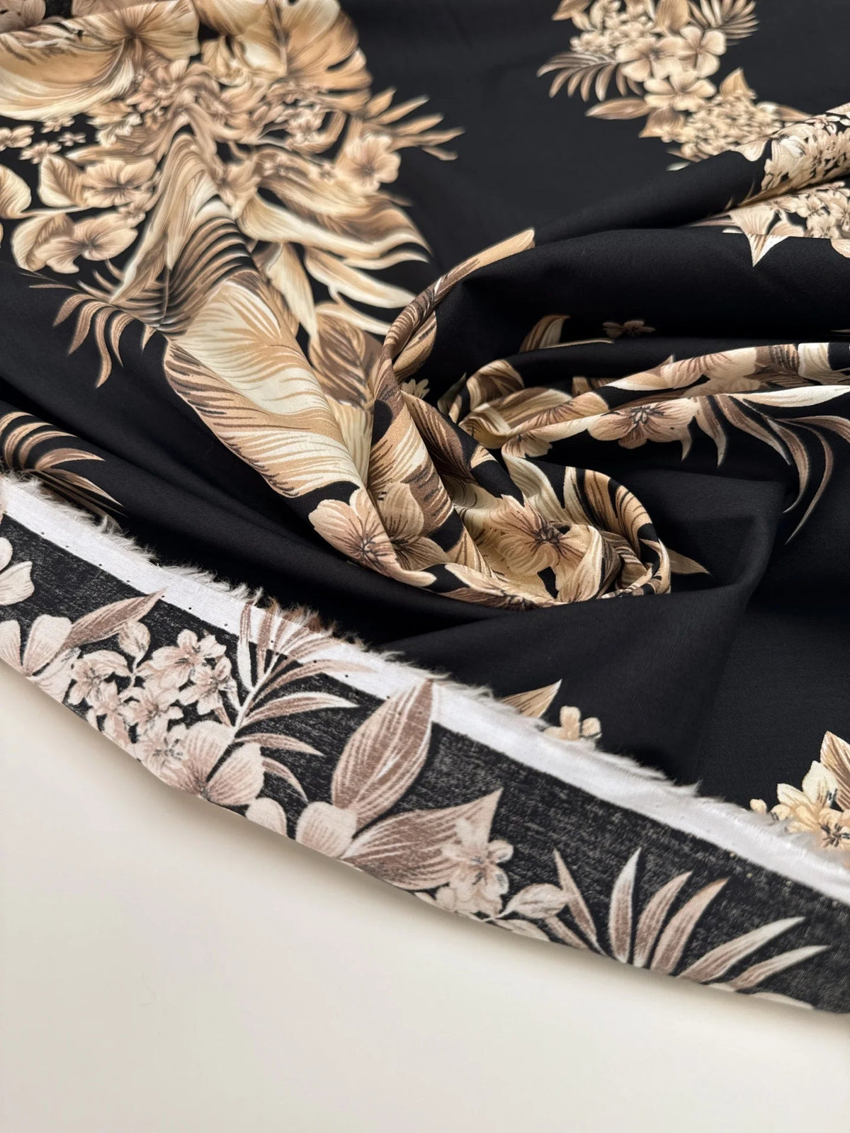 Image of Italian cotton fabric with a tropical floral pattern on a black background – available online at Šarlotes audumi