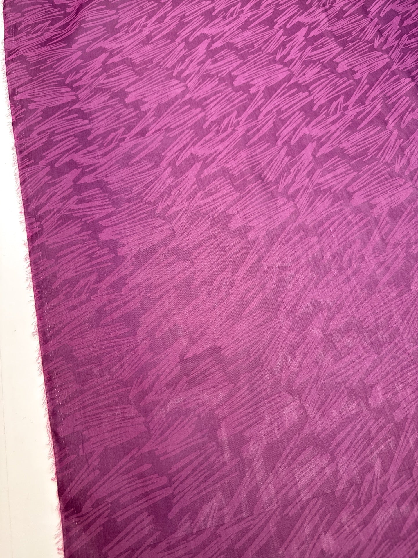 Image of Italian silk satin fabric in pink and lilac tones with an abstract pattern – available online at Šarlotes audumi