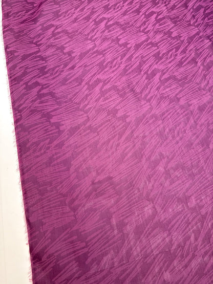 Image of Italian silk satin fabric in pink and lilac tones with an abstract pattern – available online at Šarlotes audumi