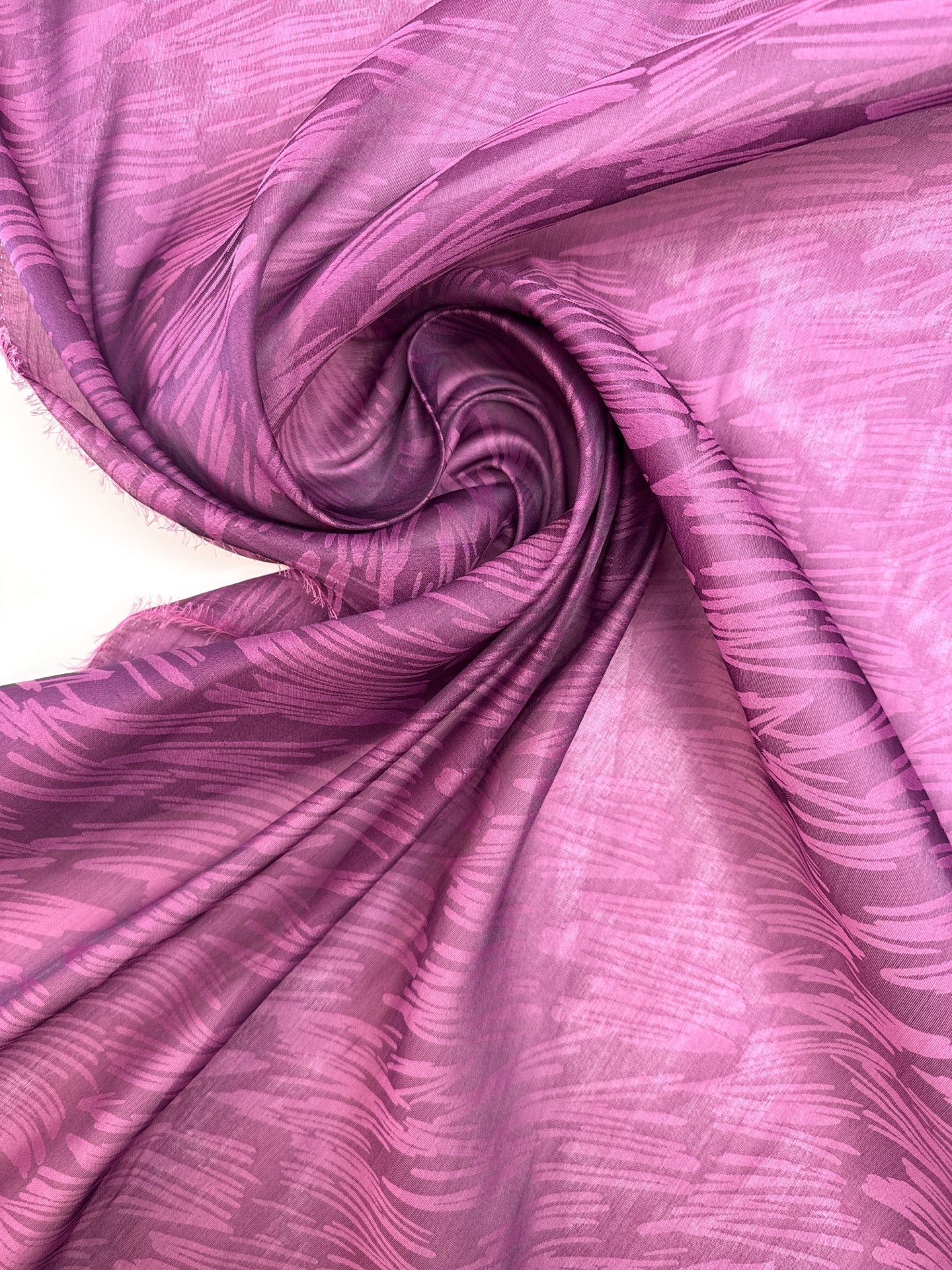 Image of Italian silk satin fabric in pink and lilac shades with an abstract pattern – available online at Charlotte's Fabrics