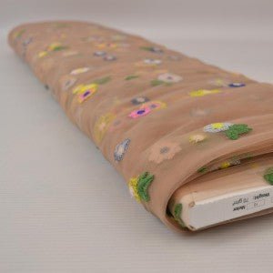 Image d’un tissu en tulle brodé à fleurs - ton pêche 70 g/m² – disponible chez Šarlotes audumi
