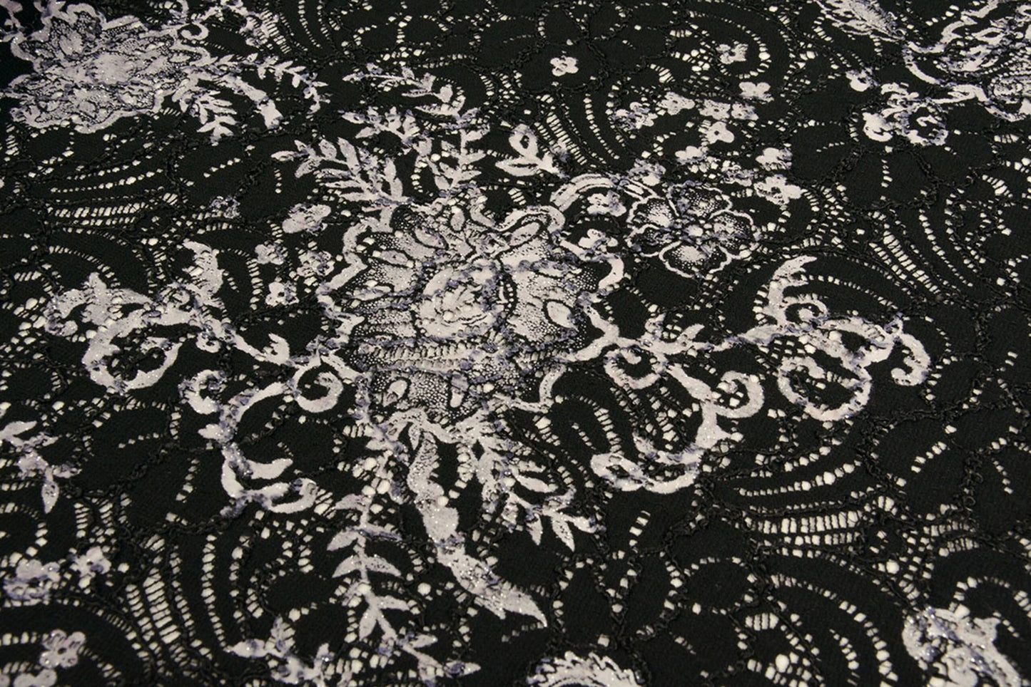 Attēls ar Mežģīņu audums - melns ar sudrabu 210 g/m² – pieejams Šarlotes audumi