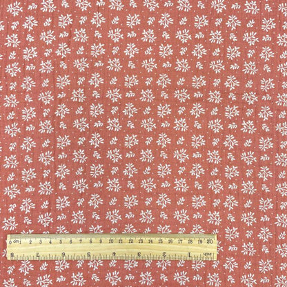 Mousseline - fleurs blanches sur fond orange 130 g/m²