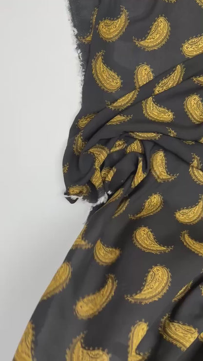 Italian 100% viscose chiffon fabric with golden paisley pattern on a black background – 100 g/m²