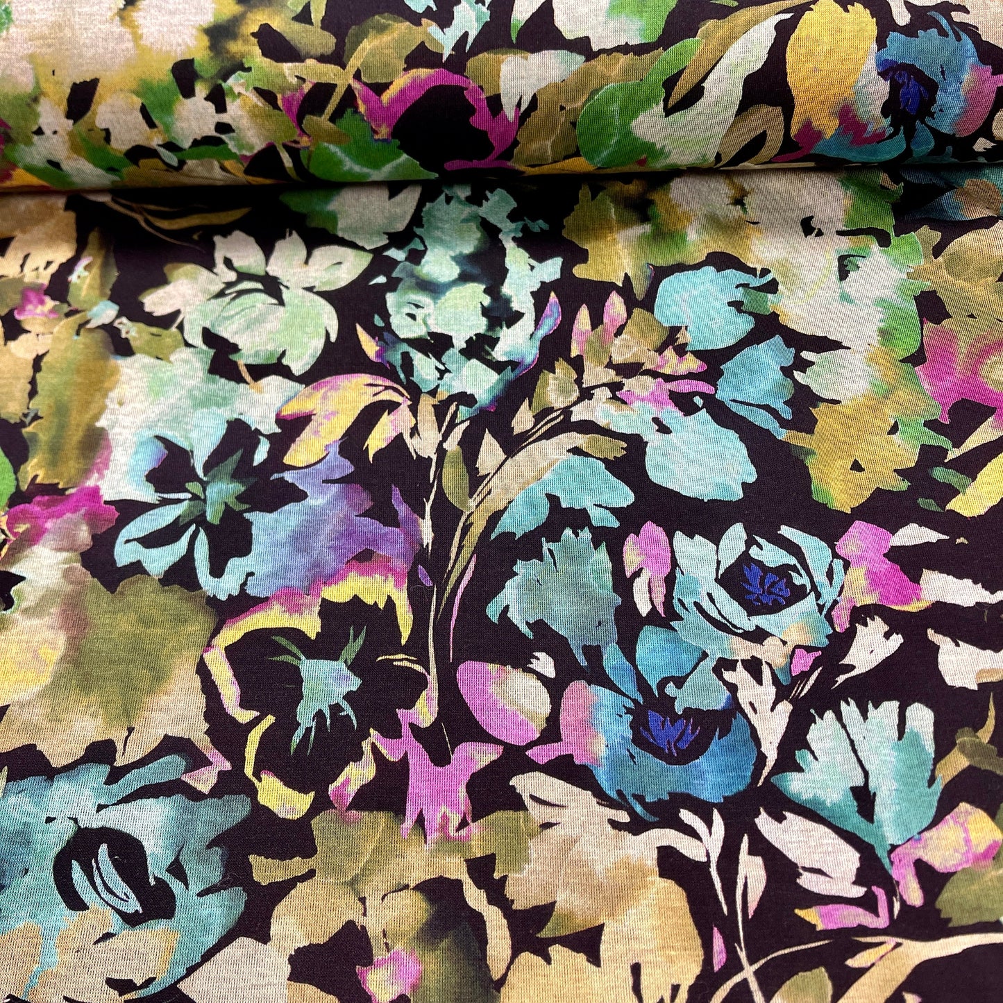 Attēls ar Punto di Roma trikotāžas audums - ziedi uz melna fona 240 g/m² – pieejams Šarlotes audumi