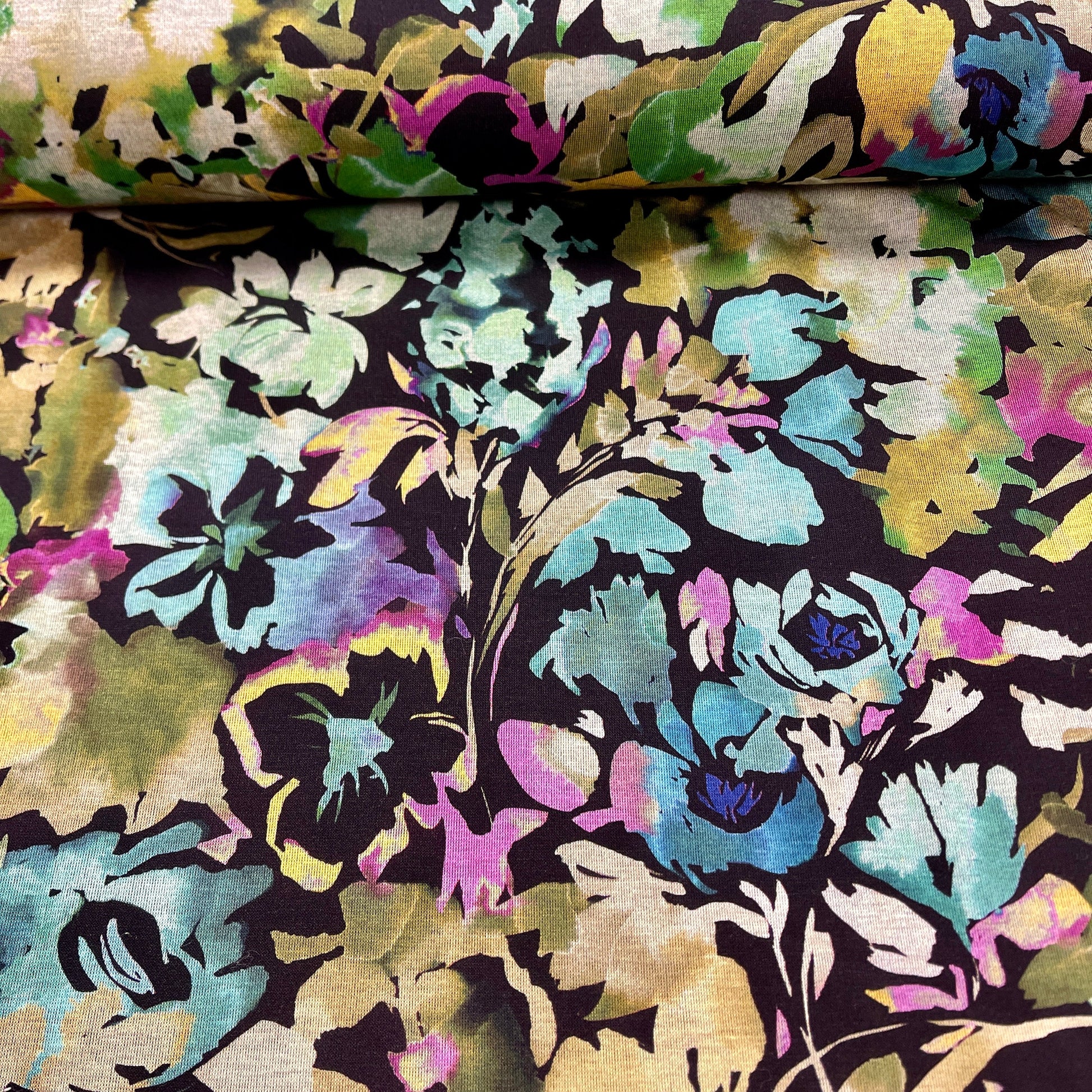 Attēls ar Punto di Roma trikotāžas audums - ziedi uz melna fona 240 g/m² – pieejams Šarlotes audumi